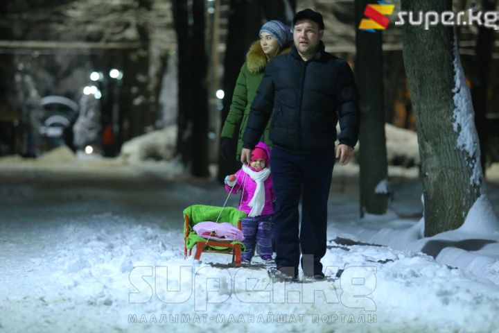 Бак аралап сейилдеп жүргөн үй-бүлө