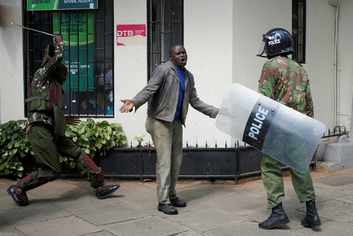 Козголоң чыгарган студенттерди полиция кызматкерлери жазалап жаткан учур. Кения.