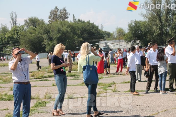 Эл жерде туруп кызыгуу менен тик учактарга көз салды. 