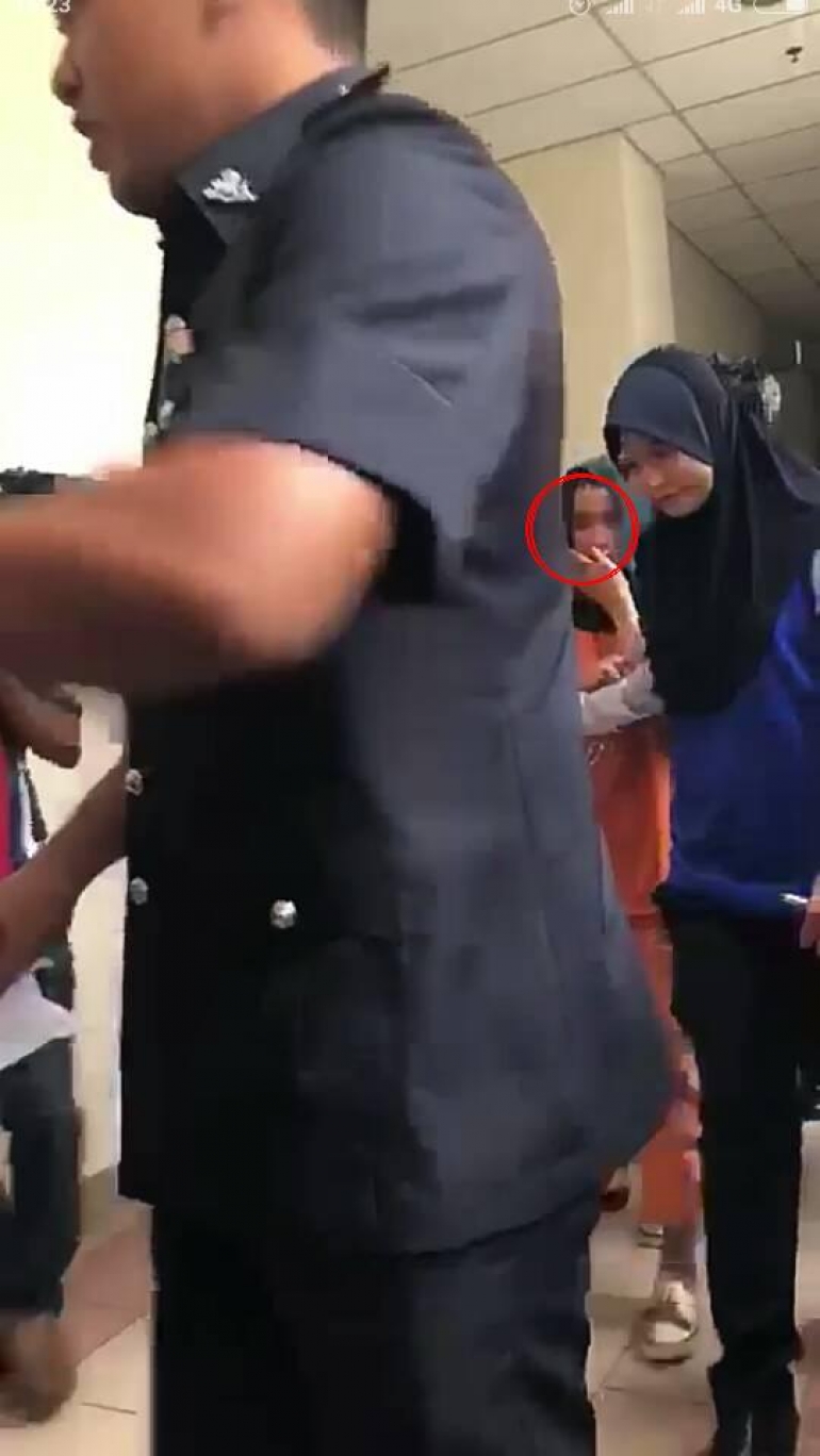 Малайзия полициясы Фарра Фаттахтын колуна кишен салып, алып бараткан учур.
